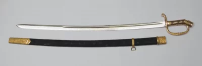 Шашка драгунская офицерская обр. 1909 г. в ножнах, Золотое Георгиевское оружие «За храбрость» (клинок) И.Р. Довбор-Мусницкого. Шаф и сыновья. 1914 - 1915 гг. Россия. Санкт-Петербург, 1914 - 1915 гг. Длина в ножнах: 99,5 см; длина без ножен: 97 см; длина клинка: 81,5 см; ширина клинка: 3 см. Золото, сталь, эмаль, ковка, литье, чеканка, полировка, гравировка, травление. ГИМ