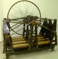 Мотор Костовича. 1883 г. С подставкой. 1883 г. Железо, бронза, сталь, заводское производство, длина - 1910 мм, ширина - 1700 мм, высота - 1870 мм. "Центральный музей Военно-воздушных сил" филиал ФГБУКиИ "Центральный музей Вооруженных Сил Российской Федерации" МО РФ.  Двигатель восьмицилиндровый, оппозитивный, с горизонтальным расположением цилиндров, соединённых в две группы по четыре цилиндра. Для равномерности хода двигателя применён маховик большого размера.