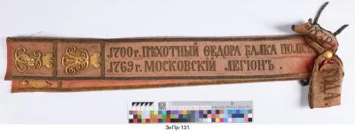 Лента знаменная александровская Днепровского пехотного полка. Россия, 1850 г. Шелк, вышивка золотом, лента: 10х75 см; бант: 25х10 см; бахрома: 10 см. ФГБУК "Государственный Эрмитаж"