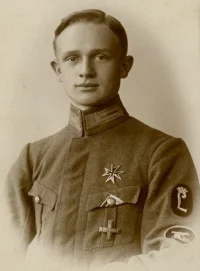 Штаб-ротмистр Западной Добровольческой армии - бывший офицер германской кайзеровской армии, состоял в пулеметной роте немецкого добровольческого корпуса фон Либермана, входившего, в свою очередь, в ЗДА.  На рукаве сверху - нарукавный знак фрайкора Либермана (увенчанная дворянской короной немецкая готическая буква "L"="Liebermann"), под ним - овальный нарукавный знак пулеметной роты оного фрайкора.  На груди - черный мальтийский "крест Авалова" - эмблема ЗДА, ниже - Балтийский крест (выдававшийся как немецким, так и русским добровольцам, сражавшимся в Латвии против большевиков вместе с "белыми" латышами до создания ЗДА), в петлице - сдвоенная ленточка прусского Железного креста 2-го класса (черно-белая) и Балтийского креста (бело-голубая).