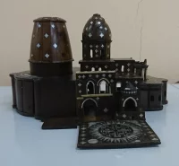 Миниатюрная копия храма гроба Господня в Иерусалиме из кипариса: трехчастная постройка, состоящая из крестово-купольного храма, ротонды и колокольни. Подземная церковь отсутствует. Крестово-купольная церковь перекрыта яйцевидным куполом, ротонда имеет покрытие в виде заоваленного цилиндра. Перед южным фасадом - вынесенная квадратная площадка с инкрустированной перламутром многолучевой звездой с вписанным в неё четырехконечным равносторонним большим крестом и четырьмя малыми (основание колокольни ?). Модель украшена инкрустацией из перламутра. На куполах и стенах - ромбические вставки, на западном фасаде квадратные и лучевидные. Вокруг алтарной части - колонки из слоновой кости. Костью обрамлены окна по южному фасаду.